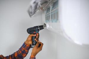 africano americano electricista reparando aire acondicionador adentro foto