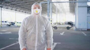 un' uomo nel un' protettivo completo da uomo e maschera a piedi attraverso un aeroporto video