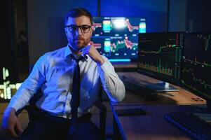 businessman comparing stock market data late in the evening photo