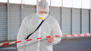 un' uomo nel un' protettivo completo da uomo e maschera a piedi attraverso un aeroporto video