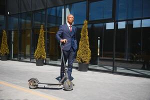 contento afro 30s hombre comprobación su teléfono durante e-scooter paseo en grande ciudad foto