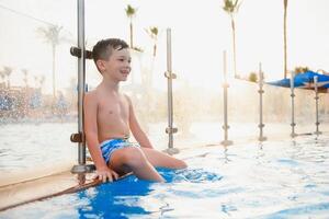 Little cute boy in blue water of the swimming pool, summer time for fun photo