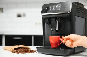 Modern coffee machine on table in kitchen photo