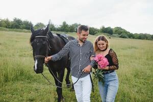 The lovely couple in love embracing near horse photo