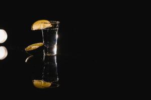 Tasty alcohol drink cocktail tequila with lime and salt on vibrant dark background. Closeup. photo