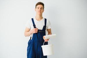 The painter is painting a wall in a room with a roller. photo