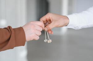 Real estate agent holding key and house model photo