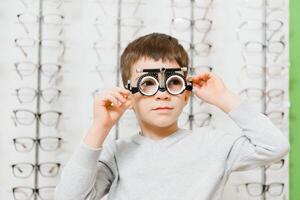 Boy with trial frame. Kid patient to check vision in ophthalmological clinic photo