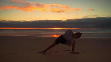 een vrouw is aan het doen yoga Aan de strand Bij zonsondergang video