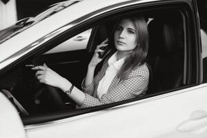 hermosa mujer sentado a el rueda de un coche. foto