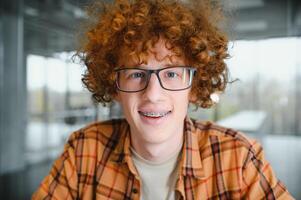 cute red-haired guy wearing stylish glasses yellow t-shirt. photo