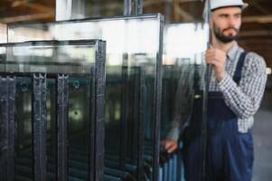 the glazier takes a piece of mirror off the table. Glass factory, manufacture photo