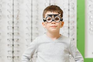 chico con juicio marco. niño paciente a cheque visión en oftalmológico clínica foto