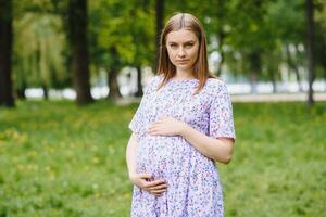 Beautiful pregnant woman relaxing in the park photo