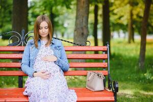 Pregnant woman resting in the park photo