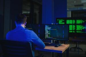 Male programmer working on desktop computer at white desk in office photo