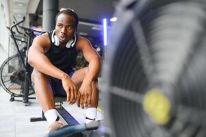 cansado, respiración y aptitud gimnasio hombre tomando un descanso desde rutina de ejercicio foto