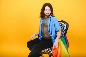 Young, handsome gay man on a colored background in the studio. LGBT concept. photo