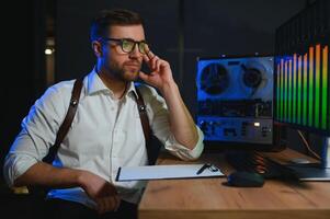 A male spy listens and records conversations on a reel-to-reel tape recorder photo