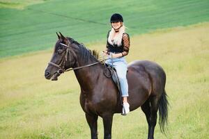 imagen de joven bonito niña montando caballo foto