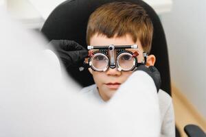 alegre niño chico en lentes cheques ojo visión pediátrico oftalmólogo foto