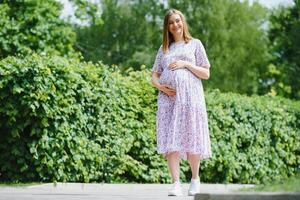 The pregnant girl on walk in city park photo