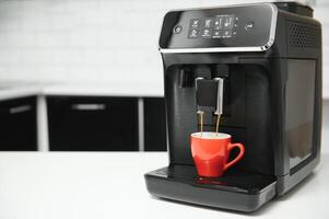 Modern espresso coffee machine with a cup in kitchen photo