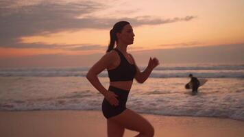 un mujer corriendo en el playa a puesta de sol video