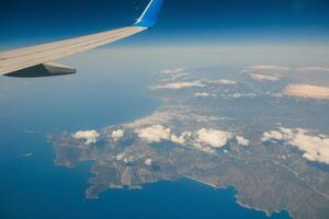 Clouds and sky as seen through window of an aircraft photo