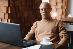 African american business man with laptop in a cafe. photo