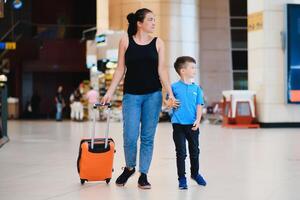 mujer y su niño paso mediante el aeropuerto terminal foto