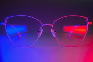 Stylish glasses shot using pink and blue abstract colored lighting with copy space. photo