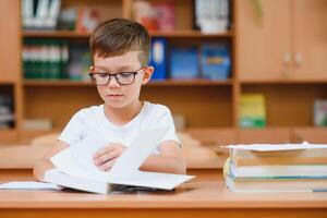 School boy in classroom at lesson photo