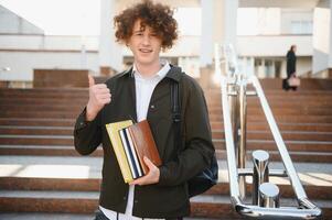 Excited student having break between classes near university, smiling to camera outdoors photo