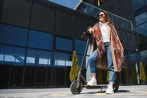 joven hermosa mujer montando un eléctrico scooter a trabajar, moderno chica, nuevo generación, eléctrico transporte, ecología, ecológico transporte, atardecer, eléctrico patineta. foto