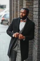 Fashion portrait of a handsome young African American business man walking outdoors in a casual pose. photo