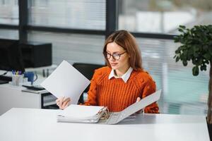 Portrait of a cute young business woman smiling, in an office environment photo