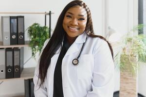 Young beautiful African American girl doctor in a white coat with a stethoscope. photo