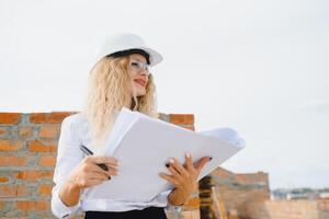 mujer ingeniero Mira a edificio vaso. foto