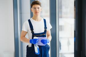 Handyman cleaning the window and smiling in a new house photo