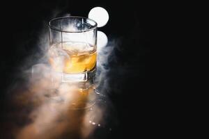 Glass of scotch whiskey and ice photo