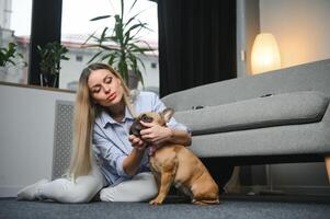 Young woman with her cute dog at home. Lovely pet photo