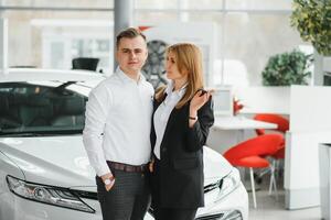 joven hermosa contento Pareja comprando un coche. marido comprando coche para su esposa en un salón. coche compras concepto foto