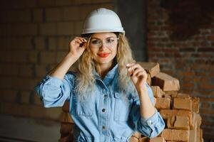 Warehouse woman worker. Woman builder in hardhat. Girl engineer or architect. Home renovation. Quality inspector. Construction job occupation. Construction worker. Lady at construction site photo