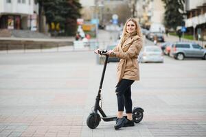 Young woman on electro scooter in city. photo