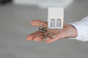 Real estate agent with house model and keys photo