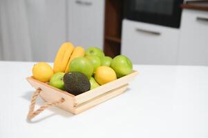 handmade kraft box with fruits and vegetables on kitchen background. photo