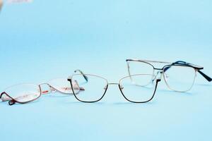 pair of red plastic-rimmed eyeglasses on a blue background photo