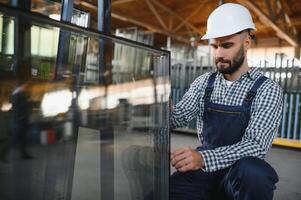 the glazier takes a piece of mirror off the table. Glass factory, manufacture photo