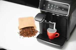 blurred background of kitchen and coffee machine with red cup and space for you photo